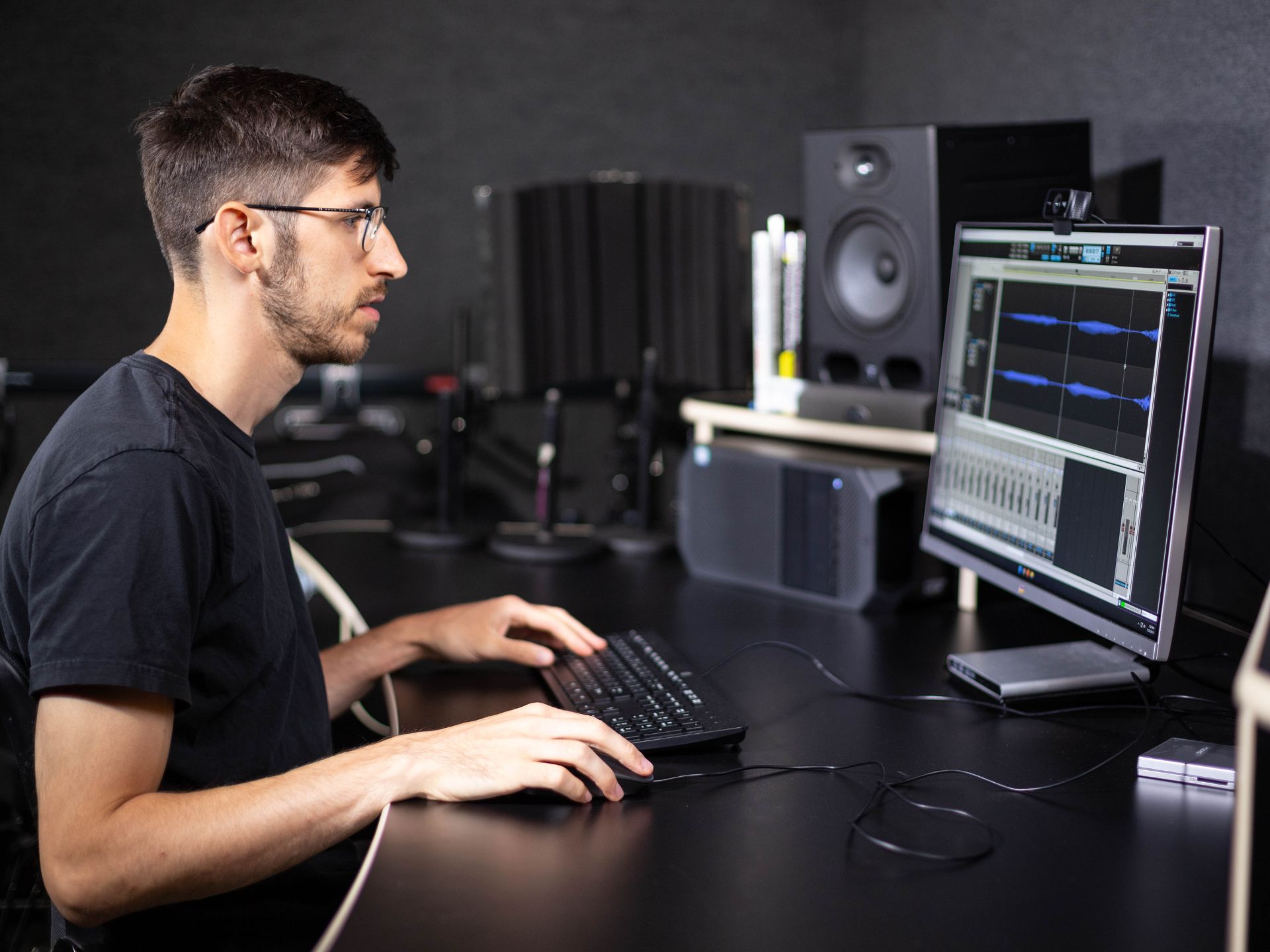A person sits at a computer using editing software