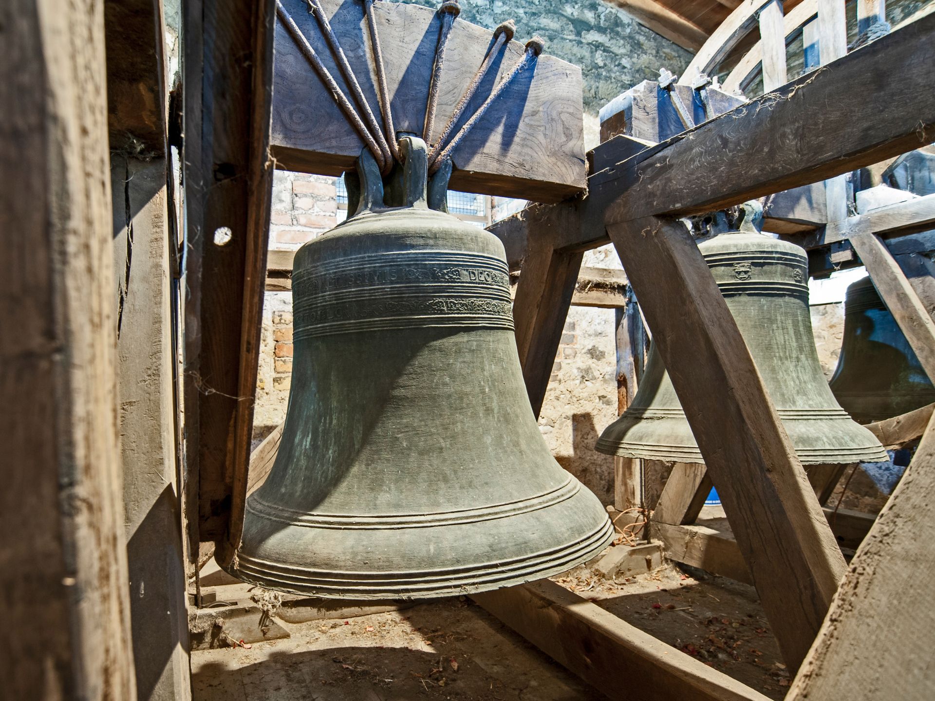 A large bell hangs from a wood structure