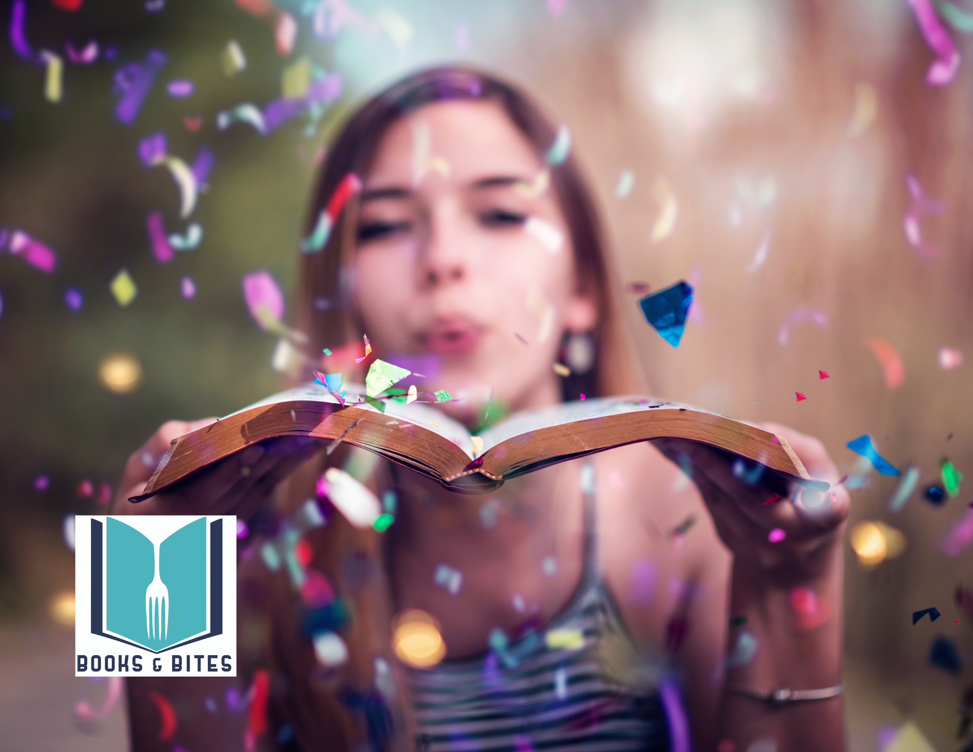 A young woman blows party confetti over a book.