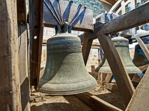 A large bell hangs from a wood structure