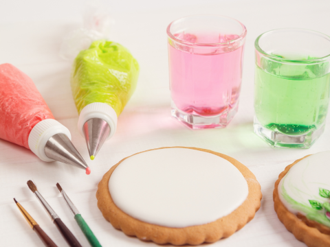 Plain cookie with icing and paintbrushes to decorate