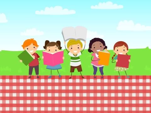 Kids holding books outside on picnic blanket