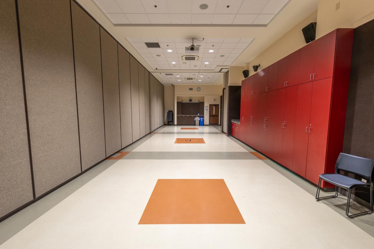 A medium-sized meeting room with red cabinets on one side.