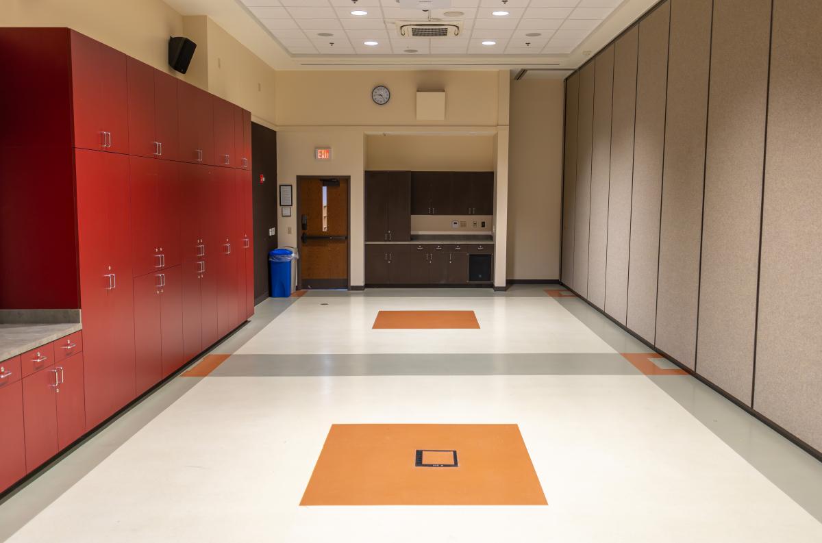 A medium-sized meeting room with red cabinets on one side.