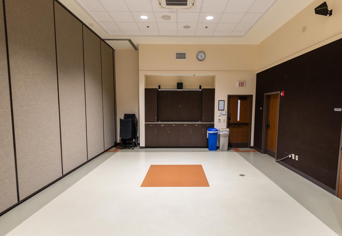 An empty meeting room with a 65" TV.